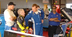 Randy and Mark and Shane in the garage discuss the car and handling, as crew chief Ritchie Howe looks on